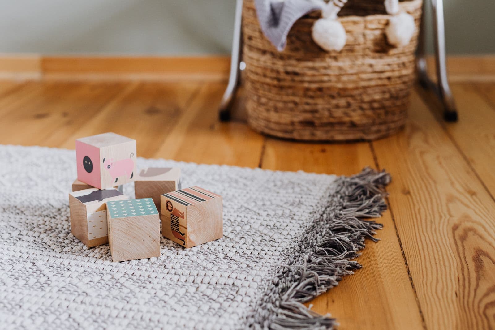 Colourful wooden blocks scattered on a woven rug in a playroom
