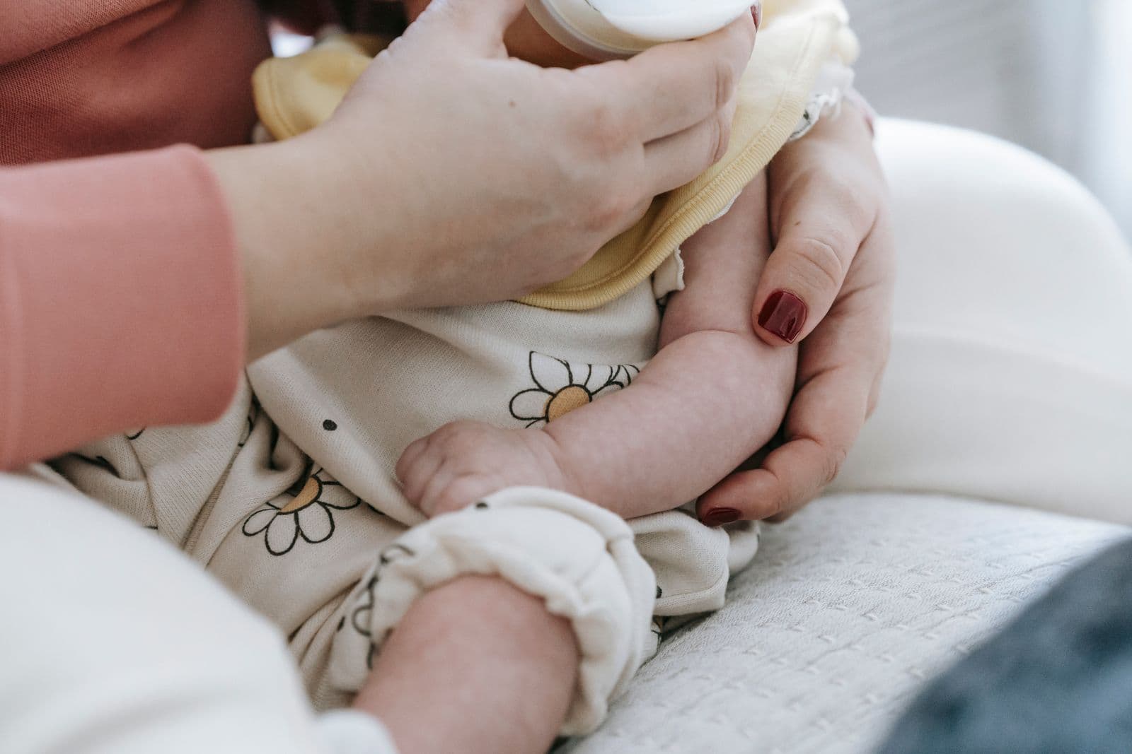 A parent holding a baby and feeding from a bottle