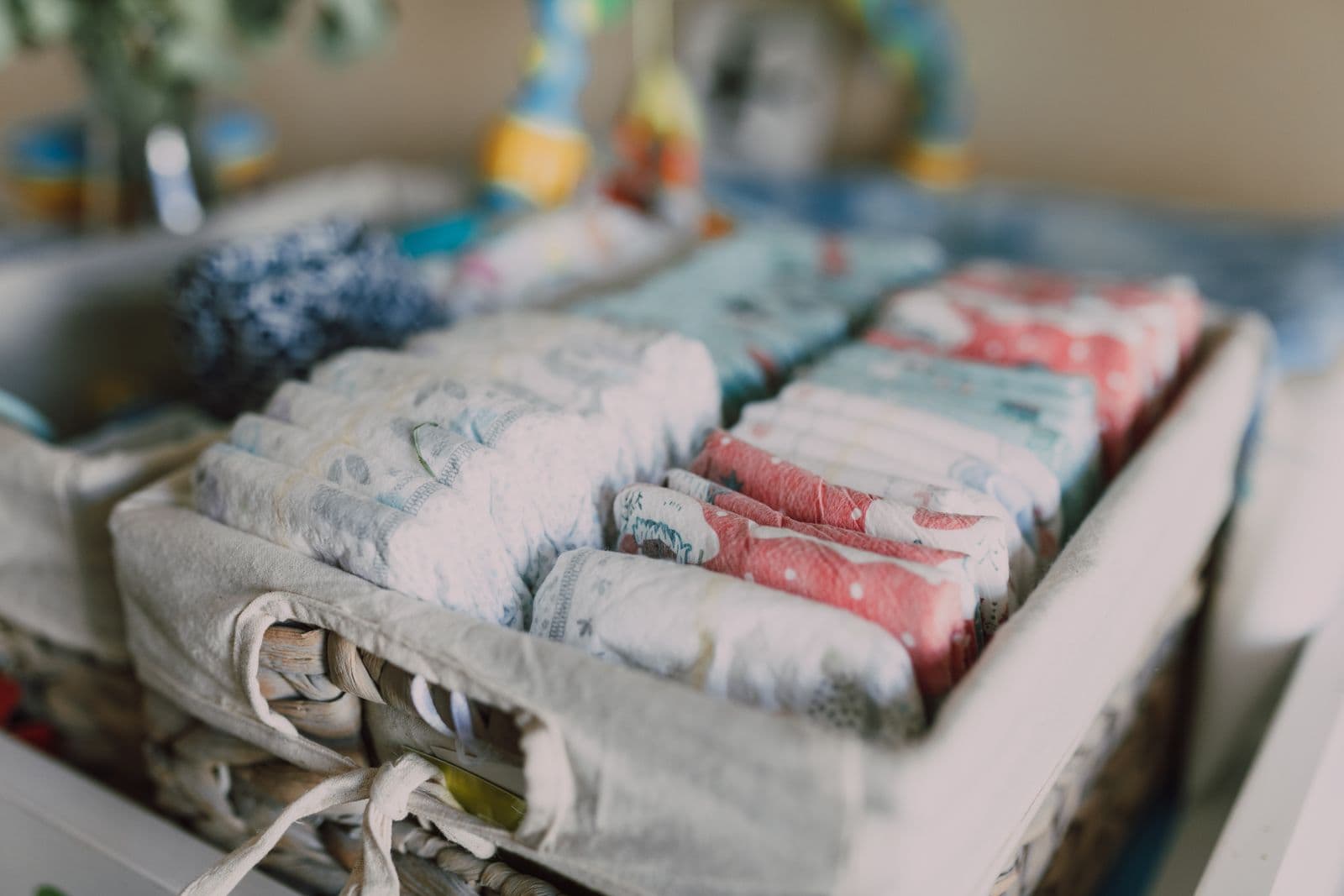 Neatly folded baby clothes and supplies arranged on a changing surface
