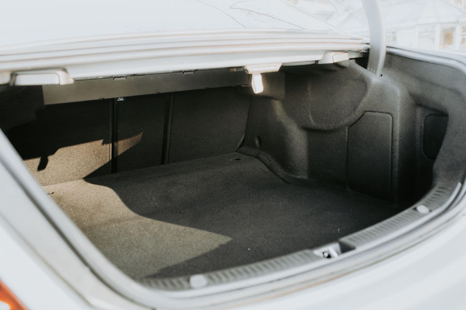 An empty car boot with the lid open, lit by daylight